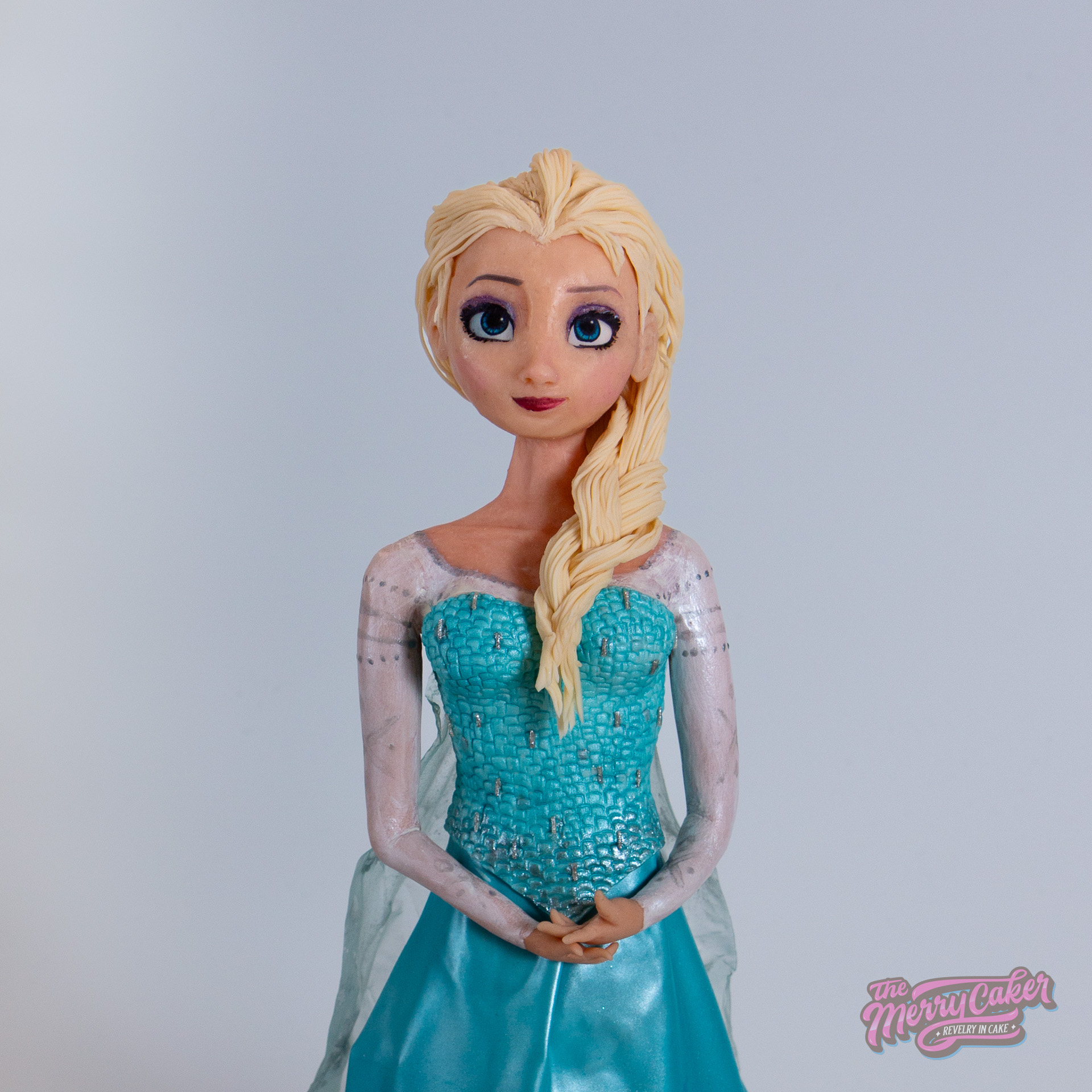 A standing 3d sculpted cake of Elsa from the Disney film Frozen