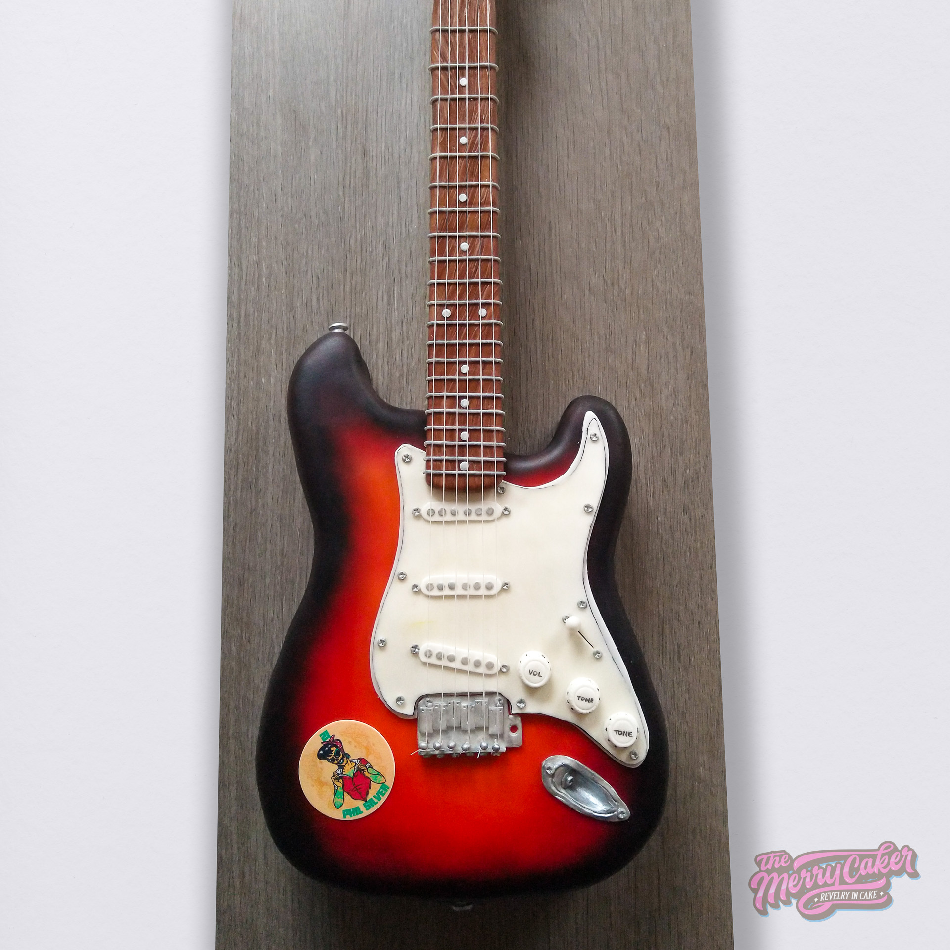 A hyper-realistic black and red fender guitar cake