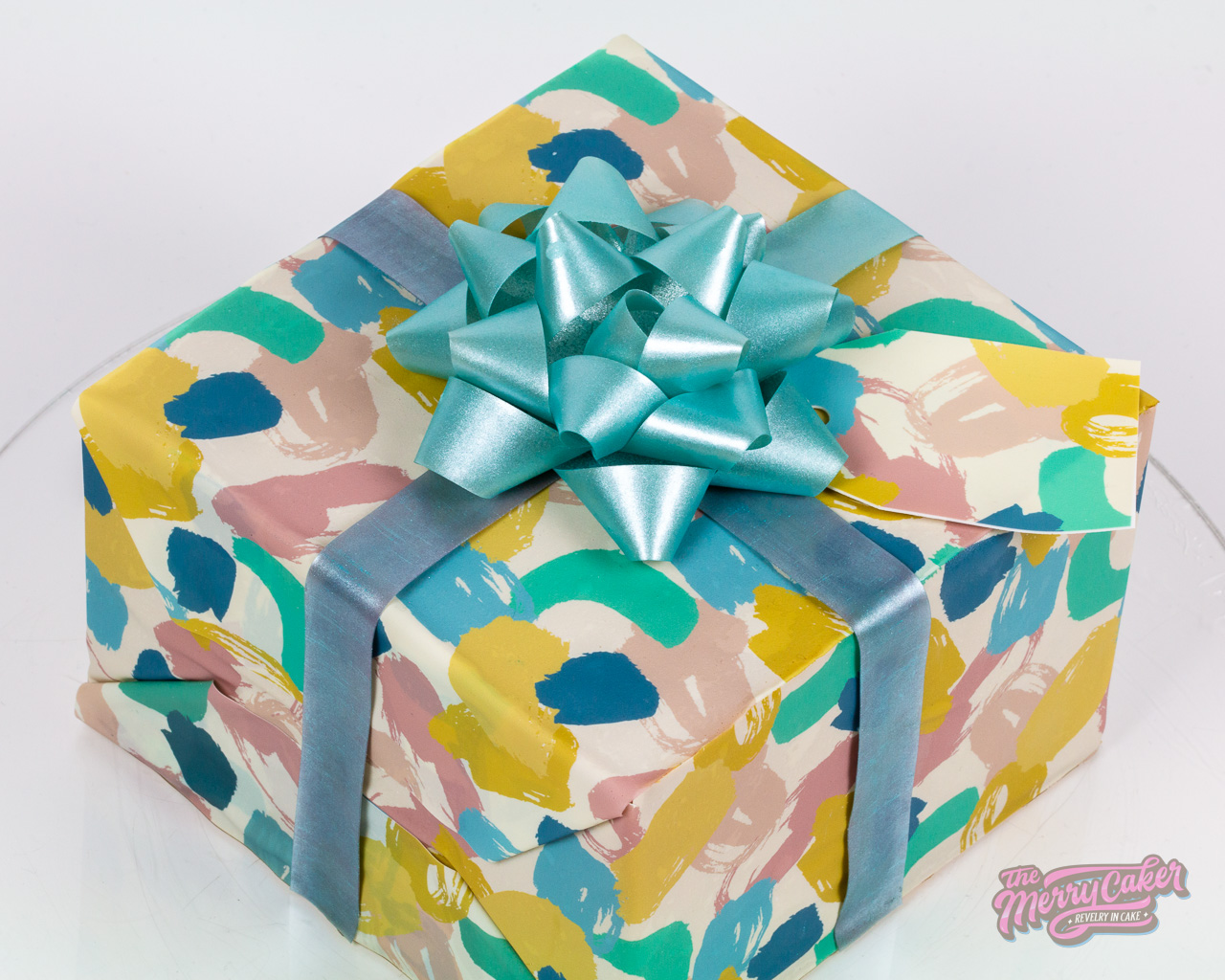 A hyper-realistic gift box present cake with an edible gift bow